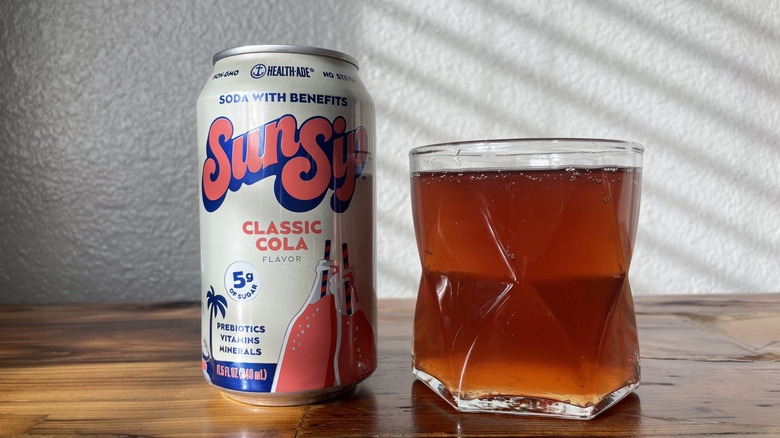 A can and glass of Sunsip Classic Cola on a wooden table