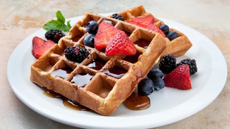 A toasty brown waffle with various berry toppings
