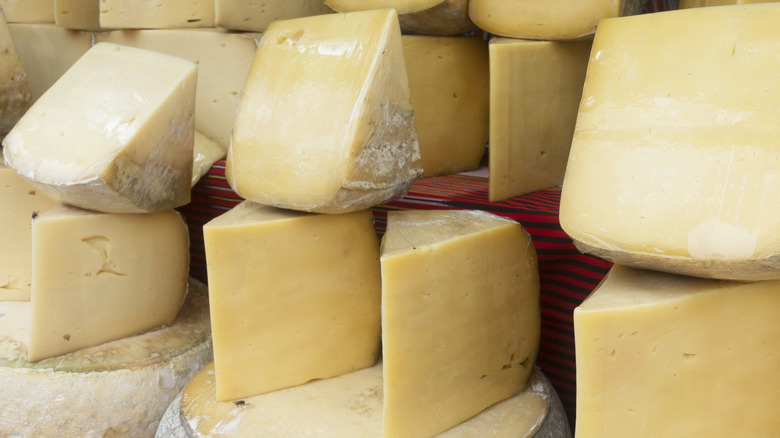 Parmesan cheese wheels and chunks on shelves