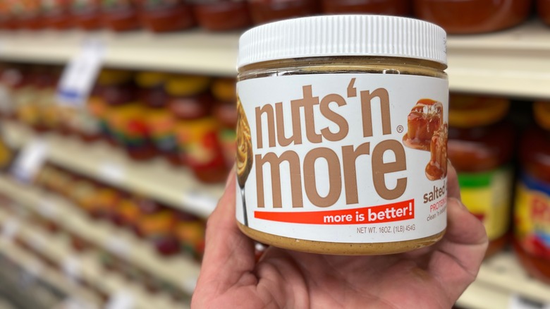 Hand holding jar of nuts 'n more peanut butter