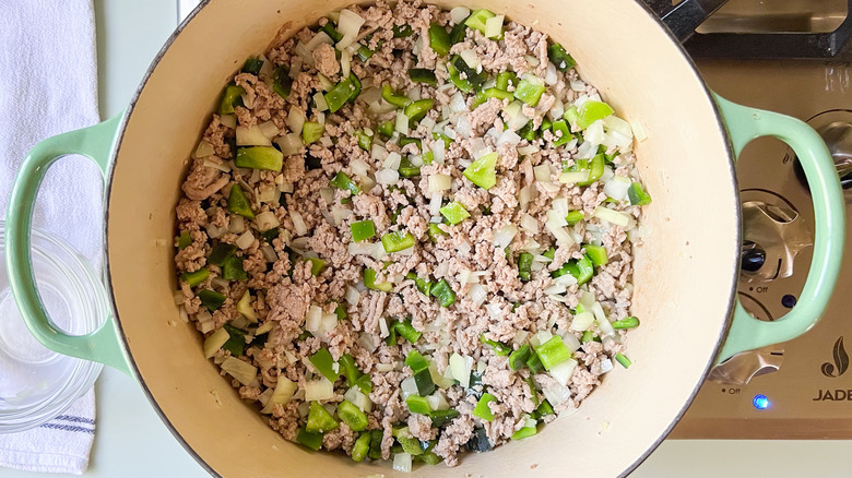 Onions, peppers, garlic, and ground turkey in pot on stove