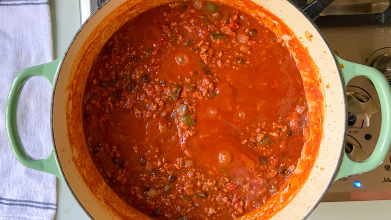 Pumpkin and turkey chili cooking in pot on stove