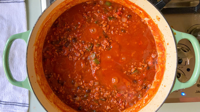 Pumpkin and turkey chili cooking in pot on stove