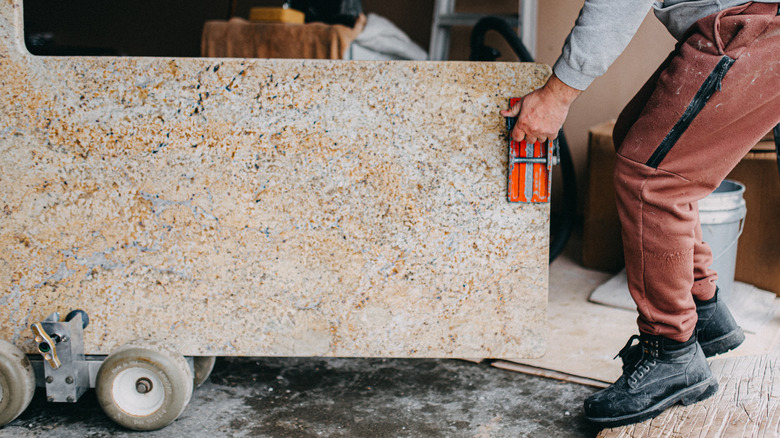 person with a slab of granite