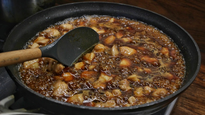 chicken simmering in sauce