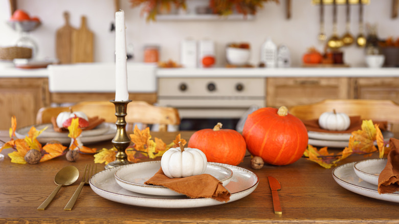 Kitchen table decorated for fall with candles and pumpkins