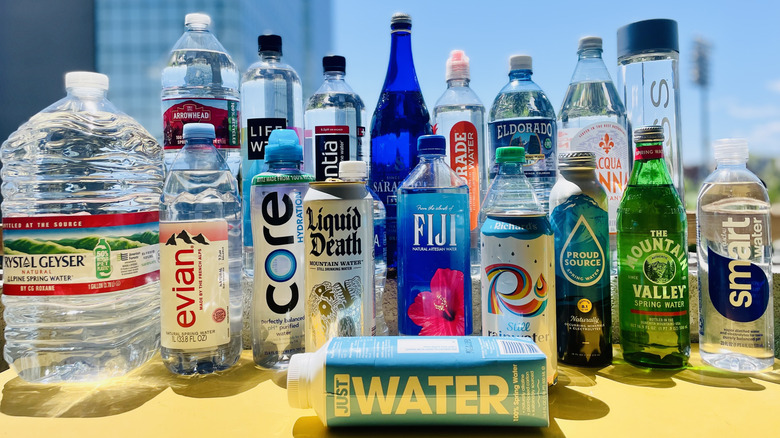 Yellow table with collection of various brands of bottled water