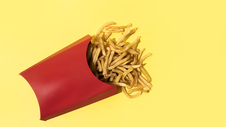 Fries in a red container with a yellow background