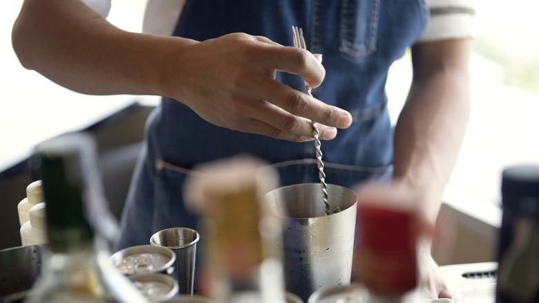 cocktail being mixed behind a bar