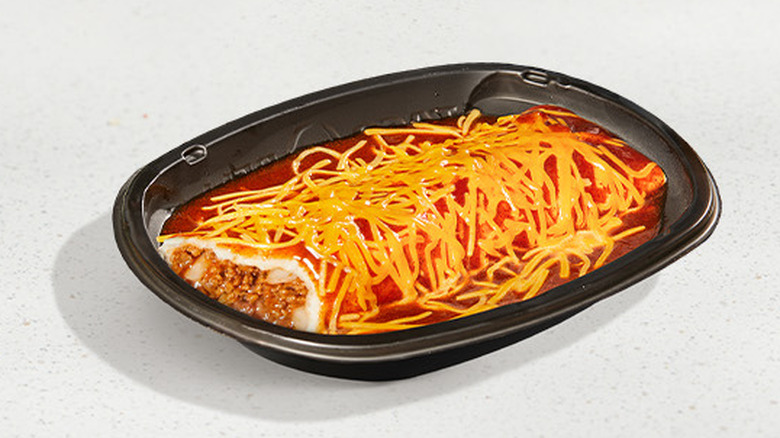 A Taco Bell Enchirito in a black, plastic tray sits on a white surface