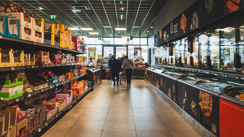 Shoppers wandering an aisle in Aldi