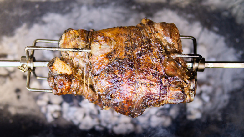 Lamb glazed with Owensboro Dip sauce is roasted on a spit over a fire