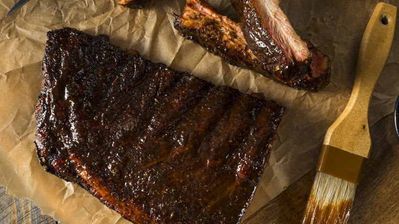 Ribs coated with St. Louis barbecue sauce lies on butcher's paper