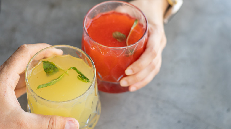 People clinking glasses of tomato juice and lemonade