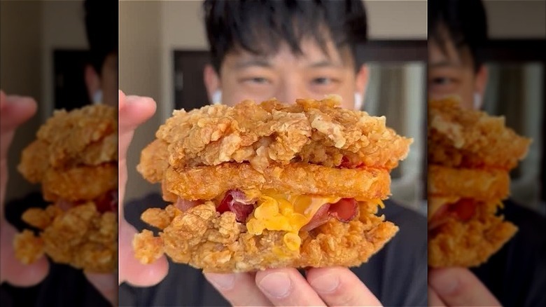 A diner holds up a KFC Double Down sandwich