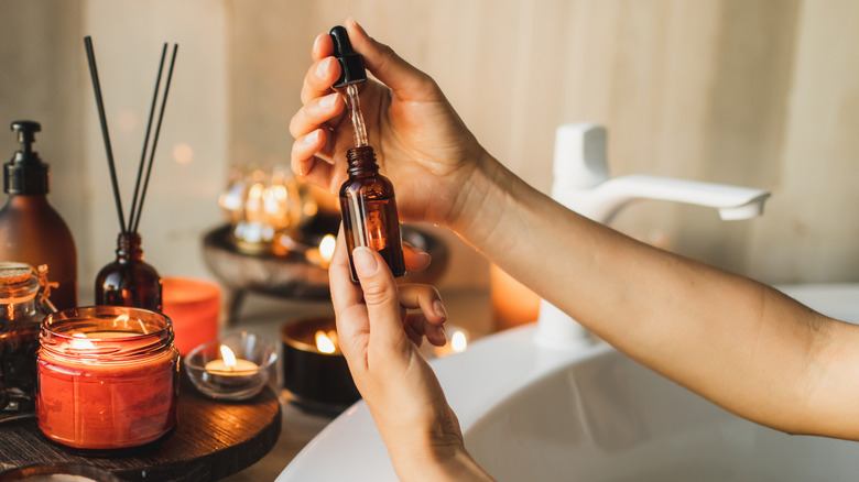 Someone placing essential oil drops into container
