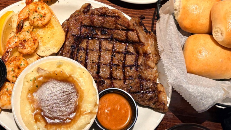 Steak and shrimp meal with bread rolls served at Texas Roadhouse