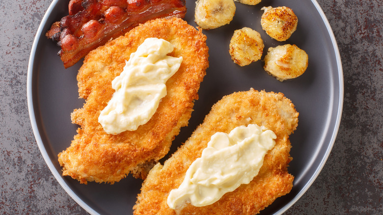 Maryland fried chicken with banana slices on a black plate