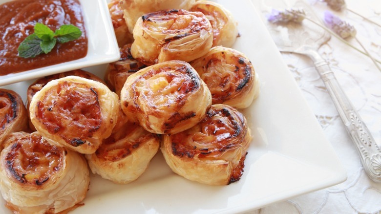 Hawaiian pizza rolls on a white serving tray 