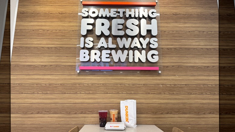 Food on table in front of sign at Dunkin'