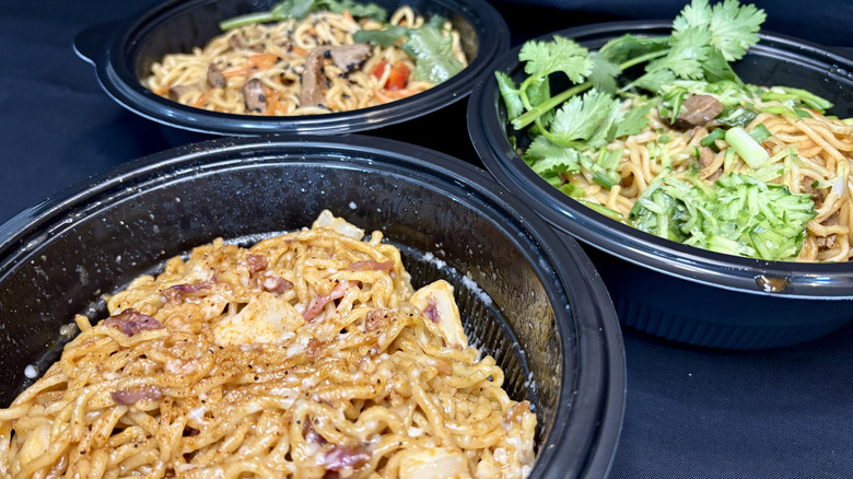 three bowls of ramen on black background