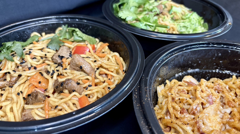 three ramen dishes in black bowls