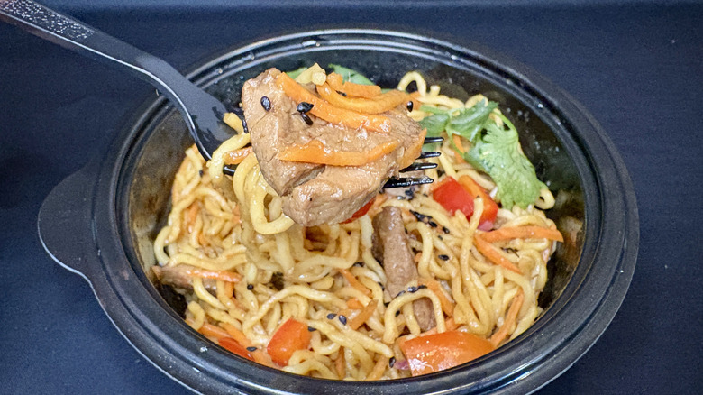 steak and sesame ramen on fork over bowl