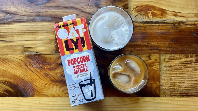 Overhead view of Oatly Popcorn Barista Oatmilk with glasses of it on ice
