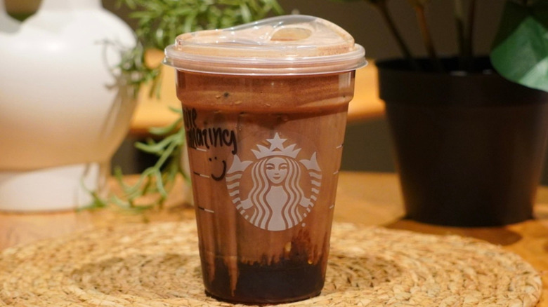 Chocolate Cream Protein Cold Brew on a woven placemat in front of plants