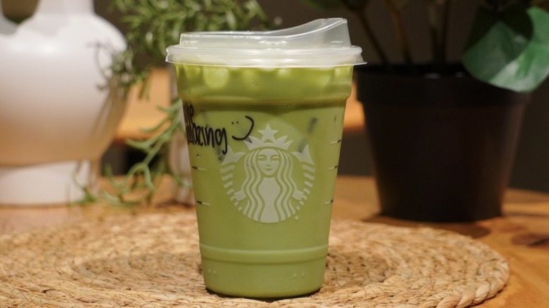 Protein Matcha on a woven placemat in front of plants