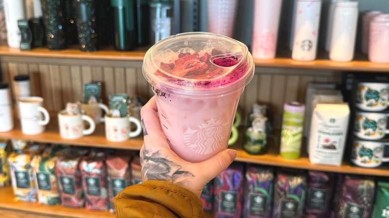 Tattooed hand holding Starbucks Pink Cannon Ball Drink