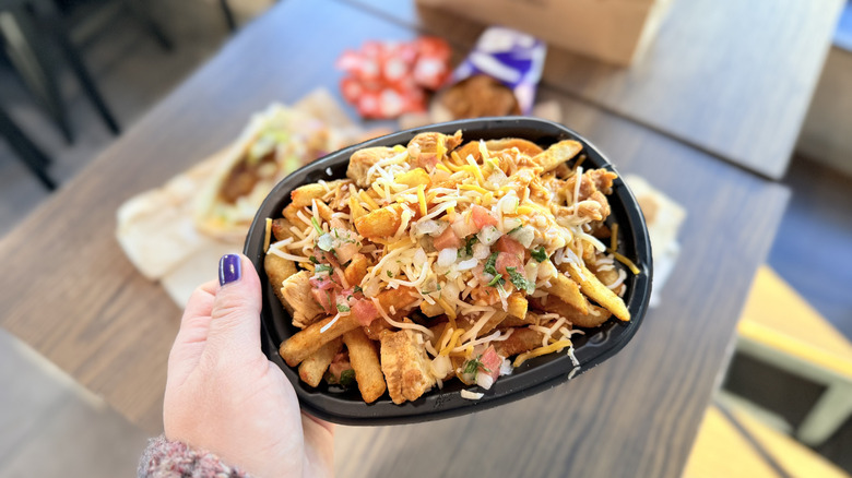 Holding up a bowl of Frank's RedHot Diablo Chicken Nacho Fries