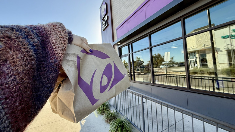 Holding Taco Bell bag outside of restaurant