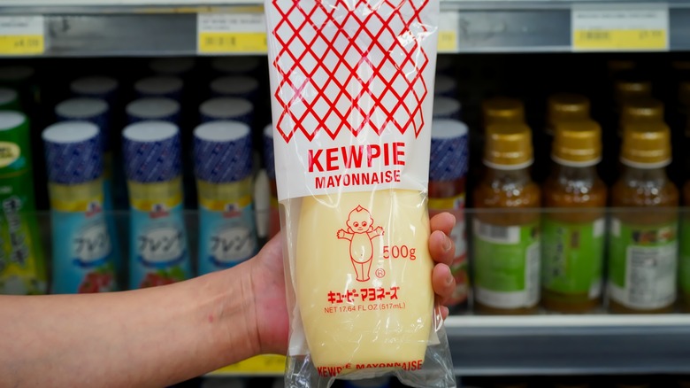Hand holding Kewpie Mayonnaise bottle