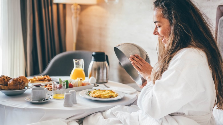 woman eating hotel room service breakfast