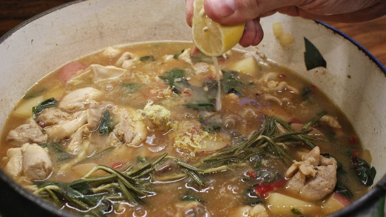 squeezing lemon half into stew