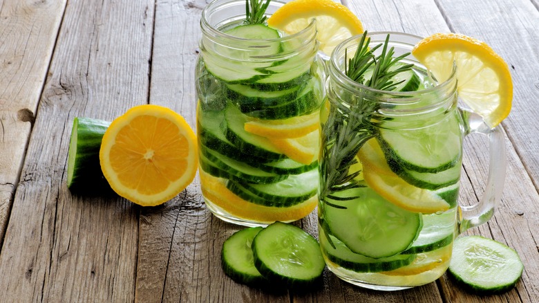 Two glasses of water with cucumber, lemon, and rosemary