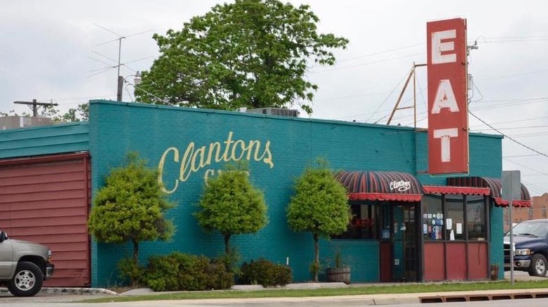 The exterior of Clanton's Cafe, it is green with a red sign that 'eat'