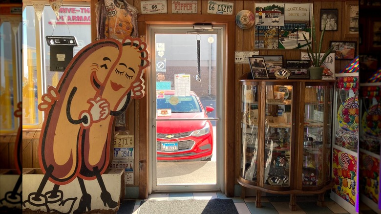 The interior of Cozy Dog, a cardboard sign of two hot dogs hugging and lot's of memorabilia
