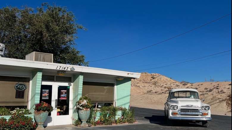 The pale green exterior of Emma Jeans with a vintage car to the right of the photo