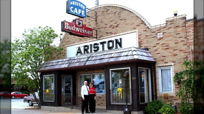 The owners of the Ariston Cafe standing outside the building