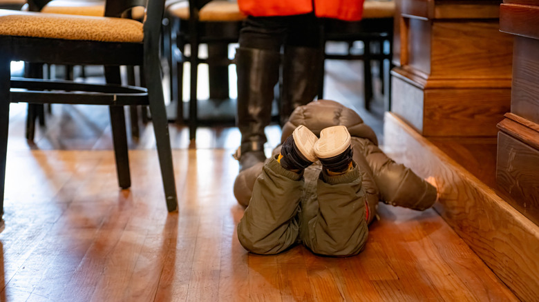 Child on the floor of a restaurant having a tantrum