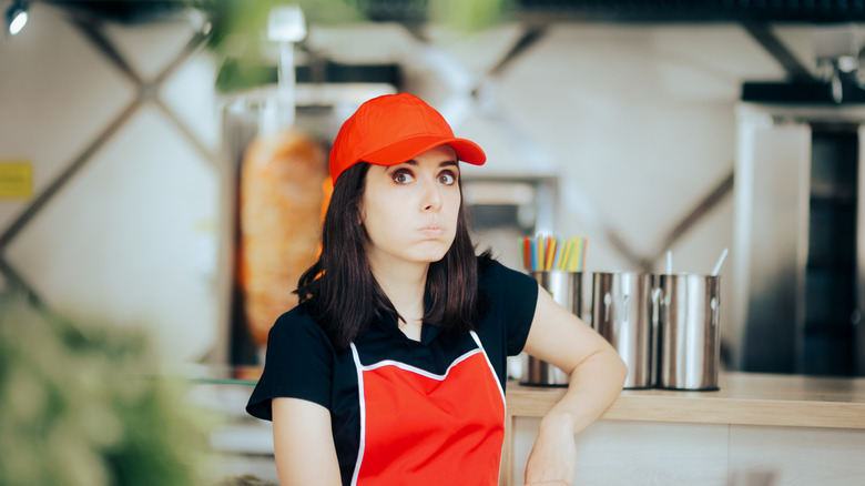 A server looking unhappy behind the counter
