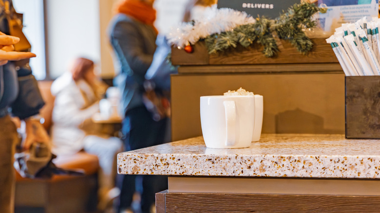 Starbucks ceramic mugs in pickup area.