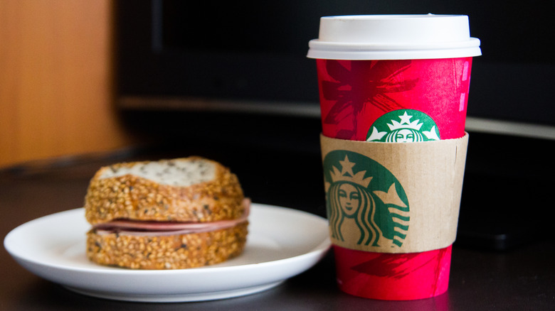 Starbucks seasonal cup and food item on white plate.