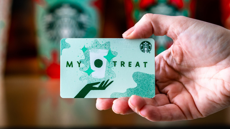 Starbucks gift card in a person's hand.