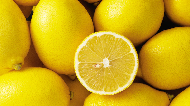 Pile of ripe lemons and one halved lemon