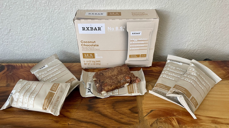 A box of RX Bar Coconut Chocolate protein bars with several outside of the box