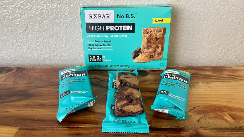 Box if RX Bar High Protein Chocolate Chip Peanut Butter with several bars lying on a wooden tabletop