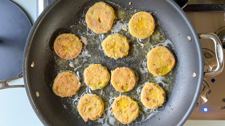 sliced tomatoes frying in pan